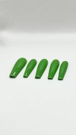 A top-down product photograph showing a set of five long, high-gloss green press-on nails arranged neatly in a row. The salon-grade gel nails are displayed on a clean, solid white background, showcasing their crisp shape, rich solid sage green color, and a flawless, reflective glass-like top coat.